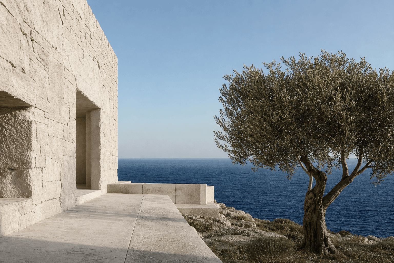 Pale stone coastal retreat with an olive tree facing a deep blue sea.